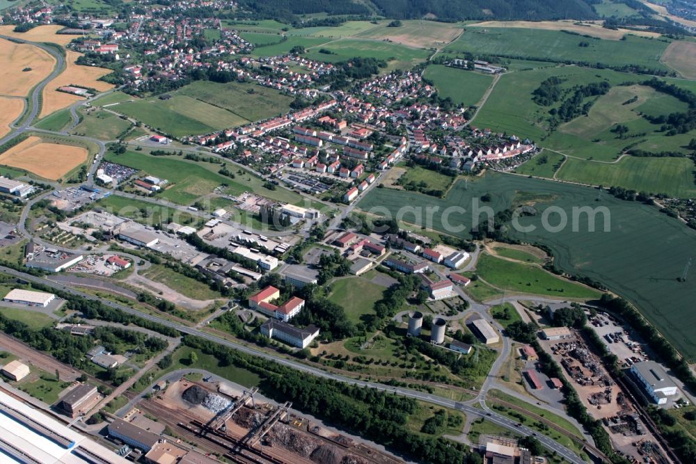 Aerial image Unterwellenborn - Directly to the site of the steel plant in Thuringia Unterwellenborn in Thuringia, the place Kamsdorf connects with its housing estates. From the steel plant storage bins for recycling and steel are on the picture to see. In the eye-catching buildings on the adjacent site, the education center Saalfeld GmbH and the State Vocational School Saalfeld are housed