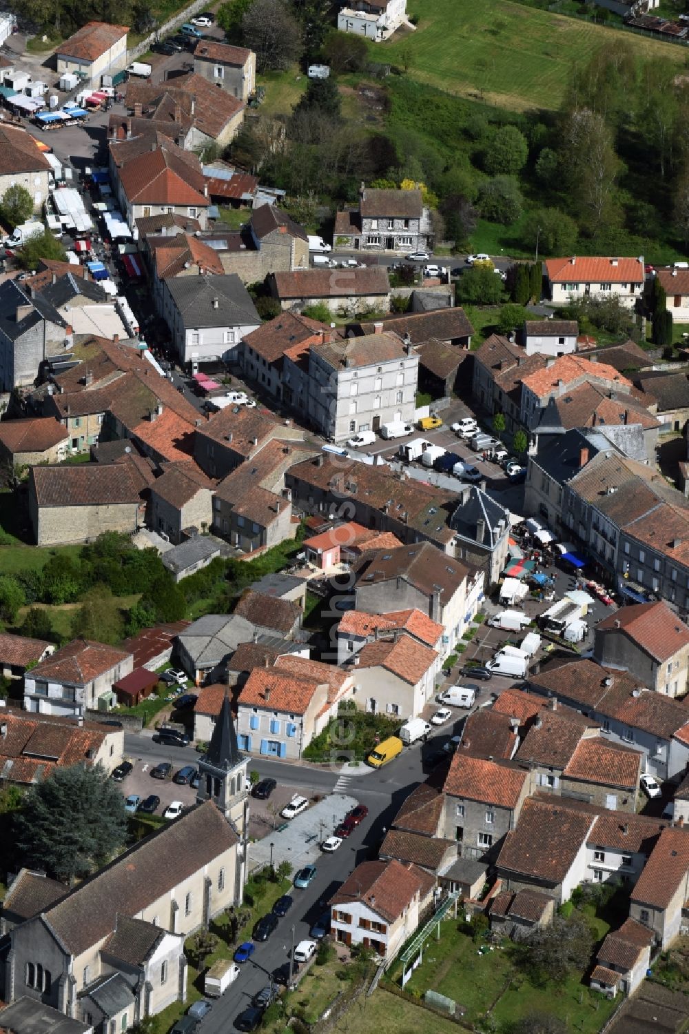 Piégut-Pluviers from the bird's eye view: Sale and food stands and trade stalls in the market place at the town hall of the inner city center in Piegut-Pluviers in Aquitaine Limousin Poitou-Charentes, France