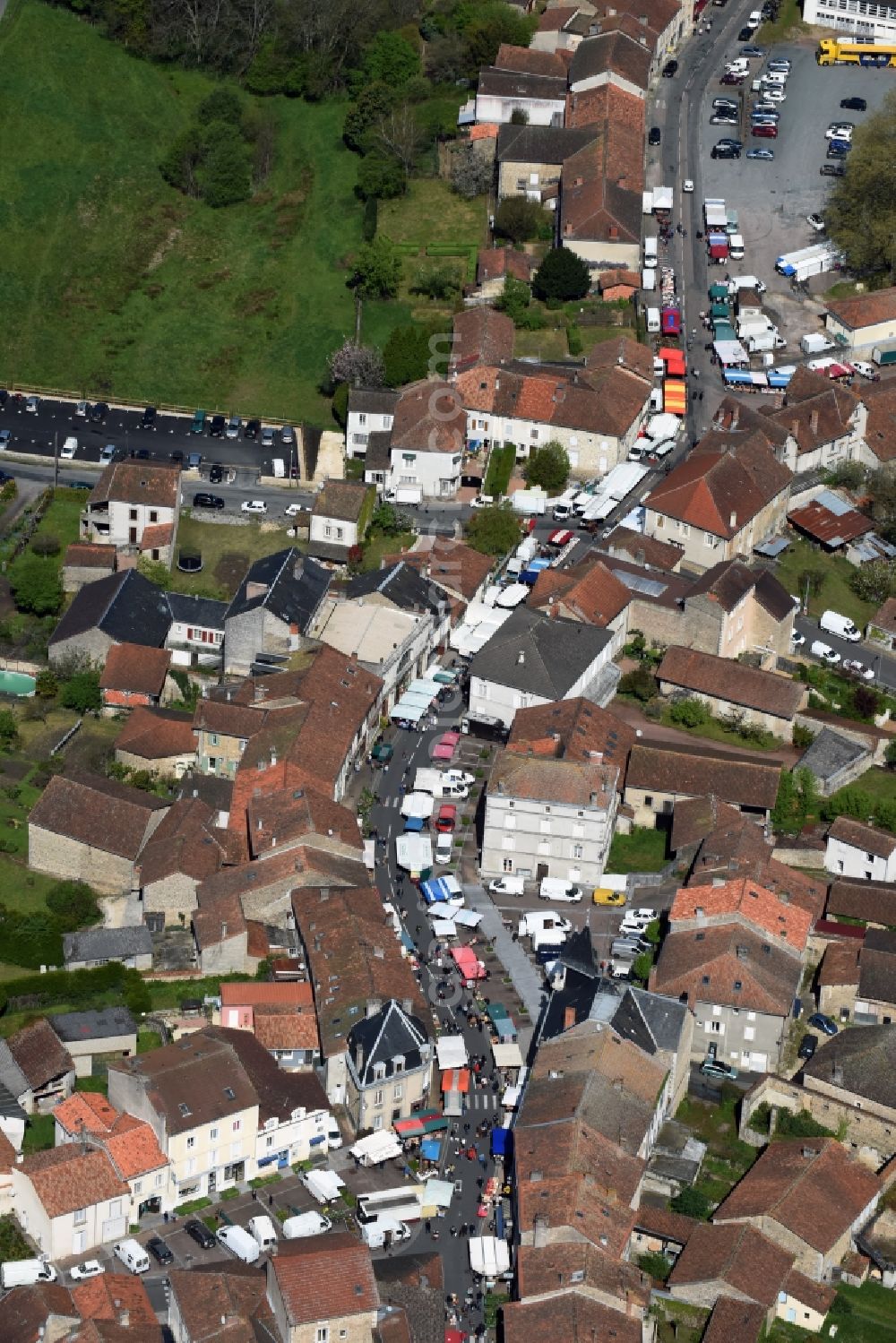 Piégut-Pluviers from above - Sale and food stands and trade stalls in the market place at the town hall of the inner city center in Piegut-Pluviers in Aquitaine Limousin Poitou-Charentes, France