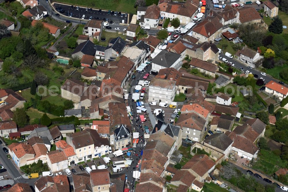 Piégut-Pluviers from the bird's eye view: Sale and food stands and trade stalls in the market place at the town hall of the inner city center in Piegut-Pluviers in Aquitaine Limousin Poitou-Charentes, France