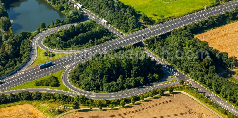 Aerial image Kirchlengern - Traffic flow at the intersection- motorway A30 and federal highway B239 in the Southeast of Kirchlengern in the state of North Rhine-Westphalia. The roads and the architectural distinct interchange are surrounded by trees and agricultural fields and located on a pond