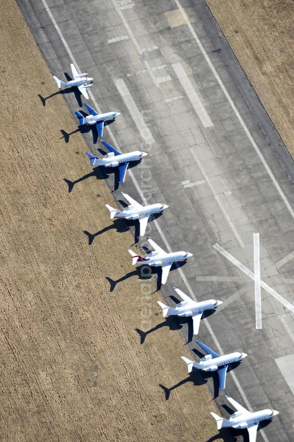 Schönefeld from above - Blick auf abgestellte Verkehrsflugzeuge und Jets der Allgemeinen Luftfahrt auf dem Reststreifen der alten Start- und Landebahn des bisherigen aktiven Teils des Flughafen Berlin-Schönefeld. Parked aircraft and general aviation aircraft on the remaining strip of the old start and runway of the recent active part of the airport Berlin-Schoenefeld.