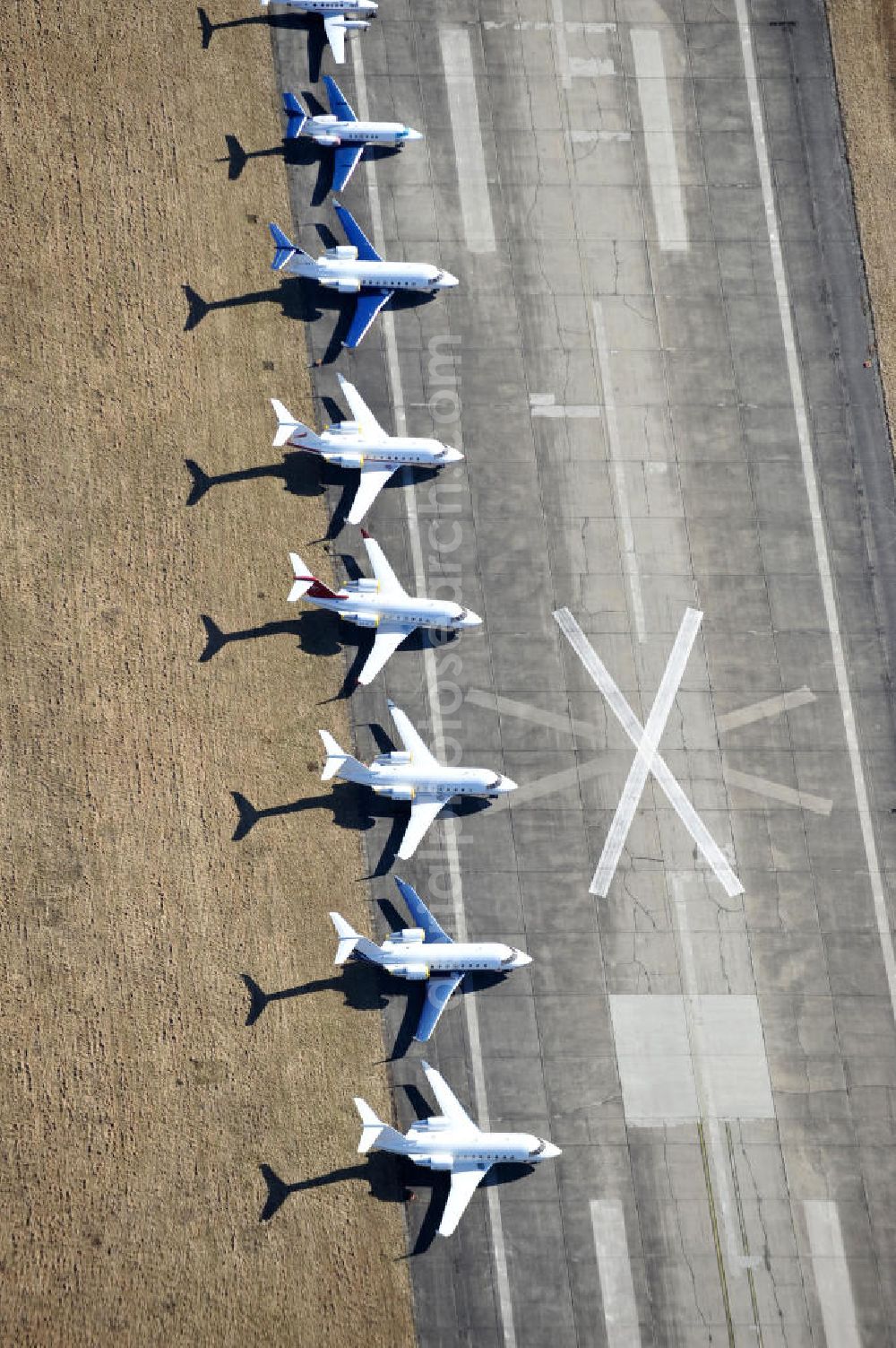 Schönefeld from the bird's eye view: Blick auf abgestellte Verkehrsflugzeuge und Jets der Allgemeinen Luftfahrt auf dem Reststreifen der alten Start- und Landebahn des bisherigen aktiven Teils des Flughafen Berlin-Schönefeld. Parked aircraft and general aviation aircraft on the remaining strip of the old start and runway of the recent active part of the airport Berlin-Schoenefeld.