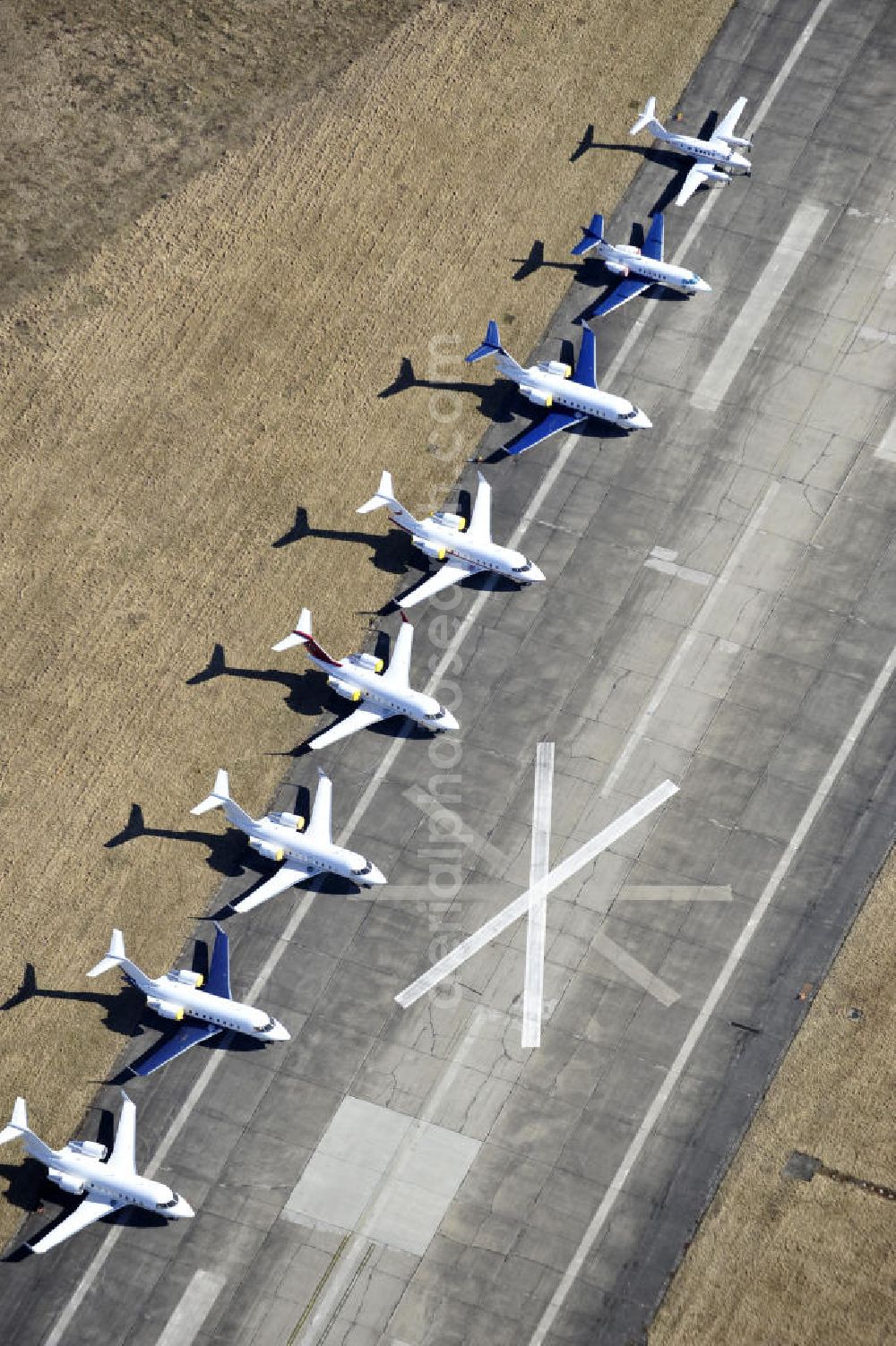 Schönefeld from the bird's eye view: Blick auf abgestellte Verkehrsflugzeuge und Jets der Allgemeinen Luftfahrt auf dem Reststreifen der alten Start- und Landebahn des bisherigen aktiven Teils des Flughafen Berlin-Schönefeld. Parked aircraft and general aviation aircraft on the remaining strip of the old start and runway of the recent active part of the airport Berlin-Schoenefeld.