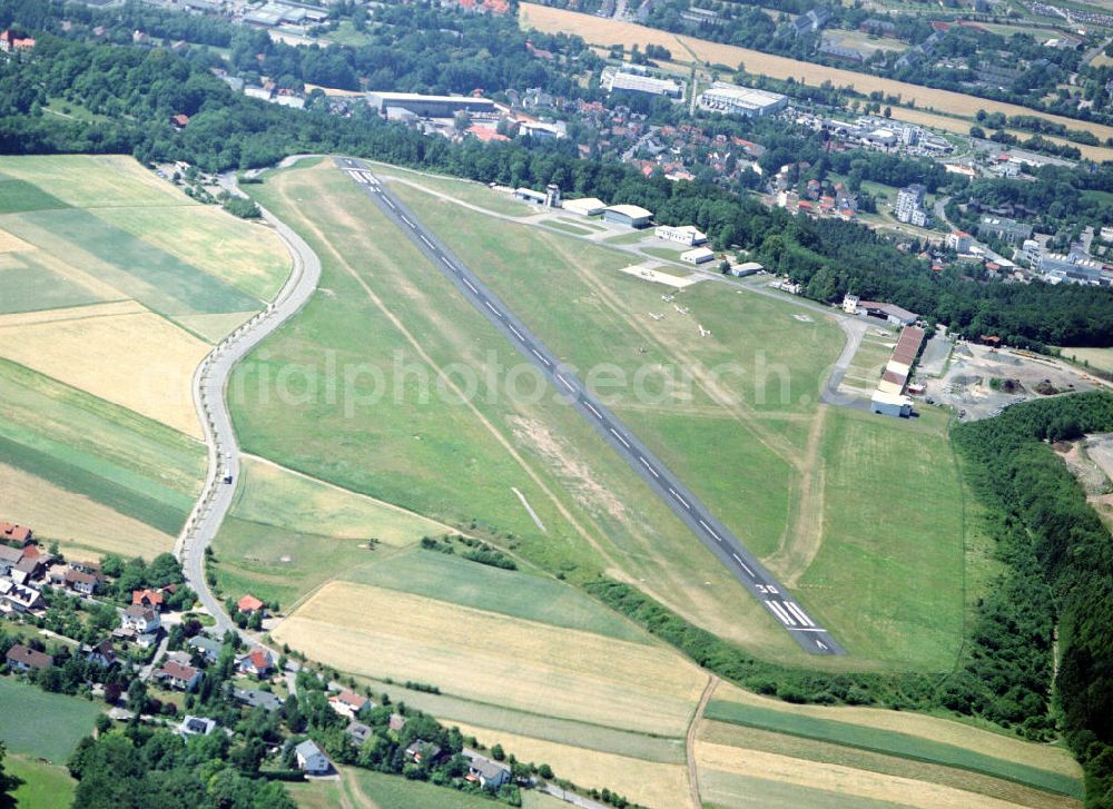 Coburg from the bird's eye view: Der Flugplatz Coburg-Brandensteinsebene liegt oberhalb der Veste Coburg. Der Flugplatz (ICAO Code: EDQC) wurde im August 1913 als militärischer Flugstützpunkt durch Herzog Carl Eduard eröffnet. Dabei waren 15.000 Besucher anwesend. Im Ersten Weltkrieg war der Flugstützpunkt Ausweichflugplatz für die Gothaer Fliegerersatzabteilung 3. Im Oktober 1924 wurde schließlich der Zivilflugplatz auf der Brandesteinsebene eingeweiht. Er befindet sich heute im Eigentum der Stadt Coburg. Betreiberschaft und Halterschaft liegen seit 2001 beim Aero Club Coburg e.V.. Der Flugplatz hat im Jahr durchschnittlich 13.000 Starts und Landungen und kann auf einer Landebahn von über 860 m Länge mit Flugzeugen bis zu einem maximalen Abfluggewicht von 5,7 Tonnen angeflogen werden. Aufgrund der Plateaulage des Flughafens sowie der sehr kurzen Landebahn ist die Brandensteinsebene ein Missionsflugplatz der Bundeswehr. Er wird zum Trainining von Starts und Landungen von der Bundesluftwaffe regelmäßig mit einer Transall C-160 der Heeresfliegerschule angeflogen.