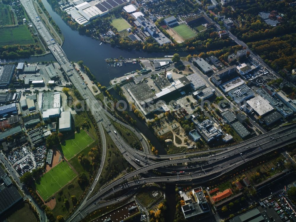 Berlin from the bird's eye view: Course of the federal motorway A100 and A113 in the area of the exit Grenzallee in the Neukoelln part of Berlin in Germany. The A100 joins the A113 towards the South. The motorway passes the harbour of Britz-East in the area which mainly consists of company compounds and commercial areas