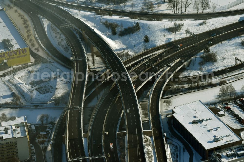 Berlin from above - Wintry snowy course of the federal motorway A100 and A113 in the area of the exit Grenzallee in the Neukoelln part of Berlin in Germany