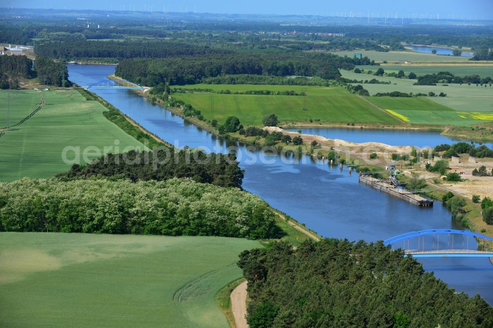 Aerial photograph Burg (bei Magdeburg) - Course of the Elbe-Havel-Kanal at the gravel pit of Niegripp in the West of the town of Burg (bei Magdeburg) in the state of Saxony-Anhalt. The distinct blue arc bridge spans the canal in the West of the town. The bridge is surrounded by forest and is one of several bridges on the canal