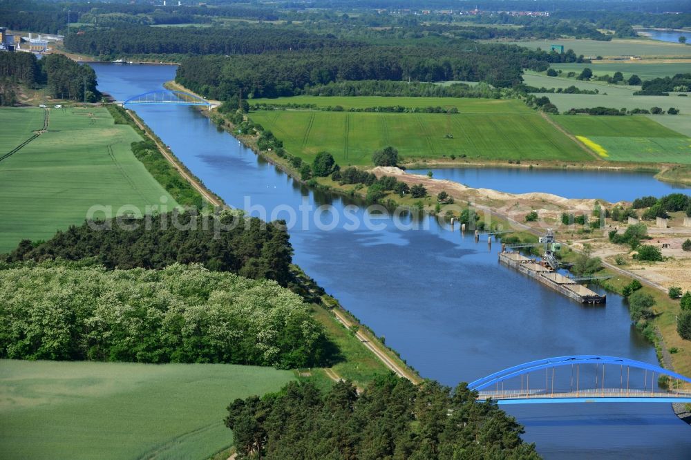 Burg (bei Magdeburg) from above - Course of the Elbe-Havel-Kanal at the gravel pit of Niegripp in the West of the town of Burg (bei Magdeburg) in the state of Saxony-Anhalt. The distinct blue arc bridge spans the canal in the West of the town. The bridge is surrounded by forest and is one of several bridges on the canal