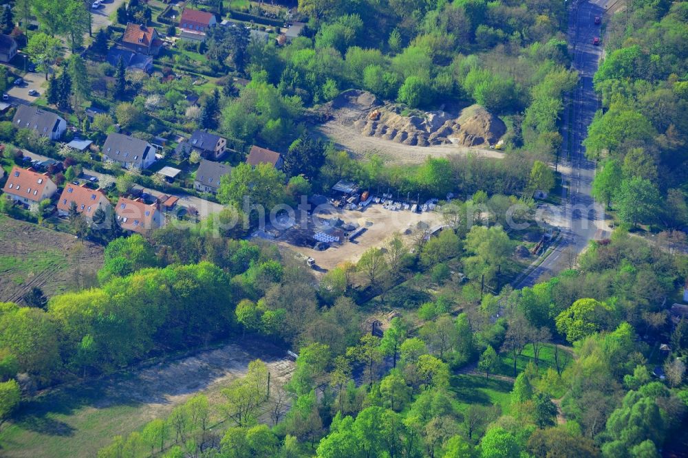 Berlin from the bird's eye view: Course of the Hultschiner Damm near the Elsenteich pond in the Mahlsdorf part of the district of Marzahn-Hellersdorf in Berlin in Germany. Several residential compounds and semi-detached houses are located on the street, as well as a construction material business in the foreground