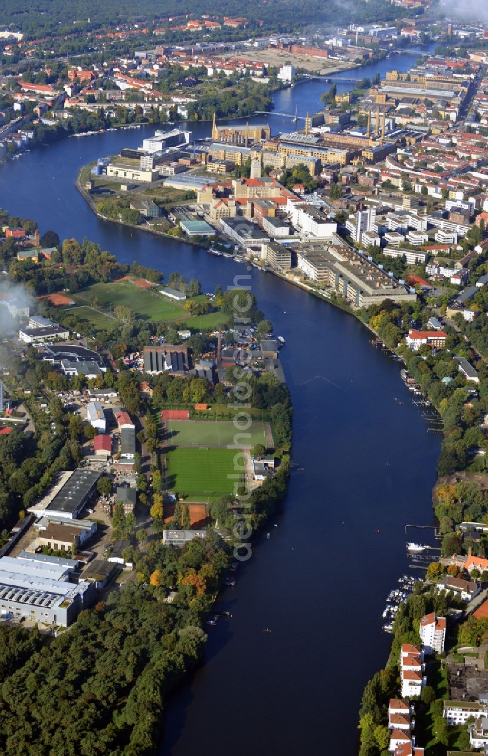 Aerial photograph Berlin - View along the course of the river Spree on the border of the districts Oberschoeneweide and Niederschoeneweide in Berlin - Koepenick. The river passes by the sports venue Kaethe Tucholla Stadion and an industry park near the Wilheminenhof Campus of the University of Applied Sciences Berlin