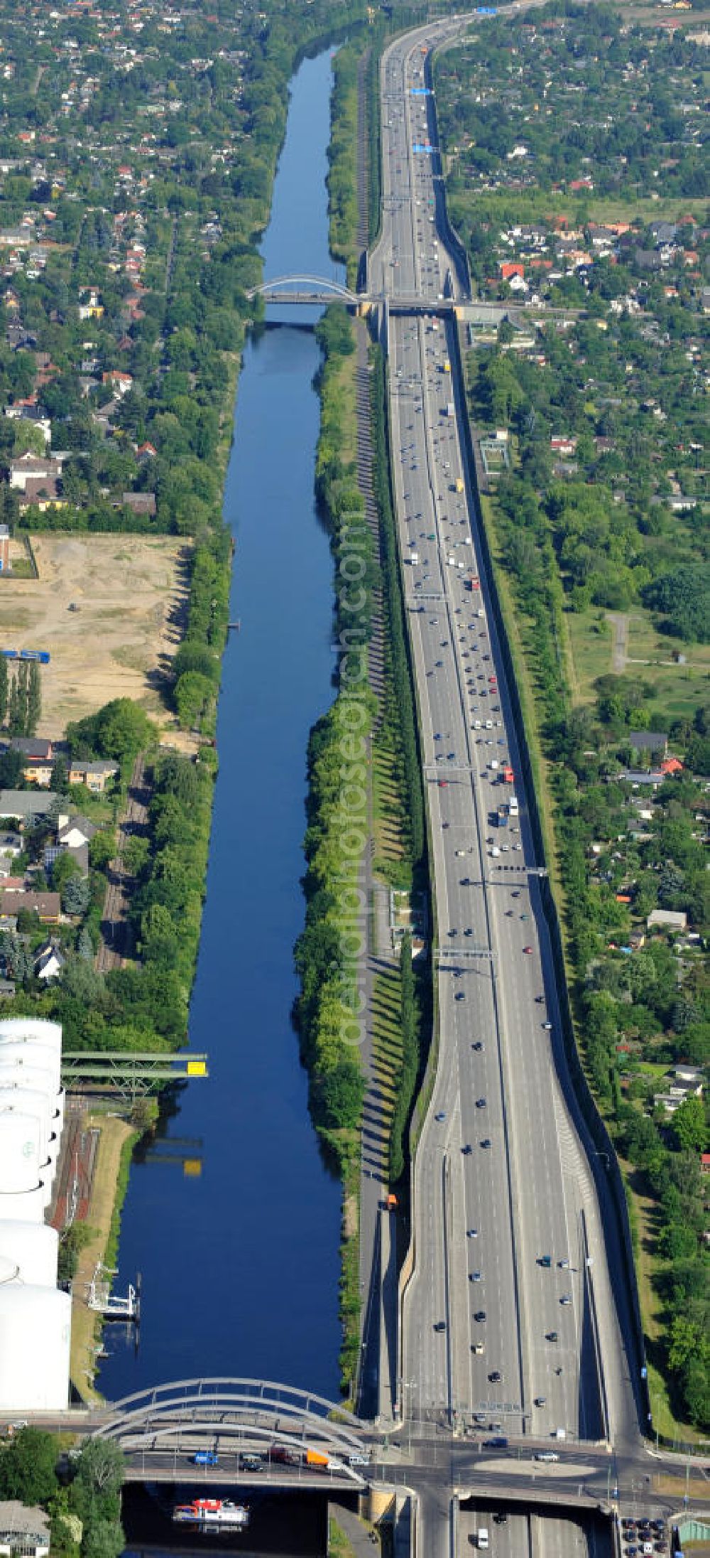 Berlin from the bird's eye view: Verlauf des Teltowkanal und der Bundesautobahn A113 von der Stubenrauchstraße / Massantebrücke neben dem Heizöl-Tanklager des Unternehmens Unitank, Richtung Johannisthaler Chaussee / Ernst-Keller-Brücke in Berlin-Rudow. Course of the Teltowcanal und the freeway A113 in Berlin-Rudow.