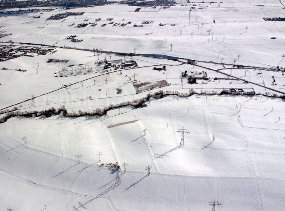 Heilbronn from the bird's eye view: Snow covered transmission lines and acres in the county district of Heilbronn in the state of Baden-Württemberg. The high voltage power lines are set up along the fields and acres in the district and the region. The different sizes, geometries and structures of the various fields in winter are still very well visible