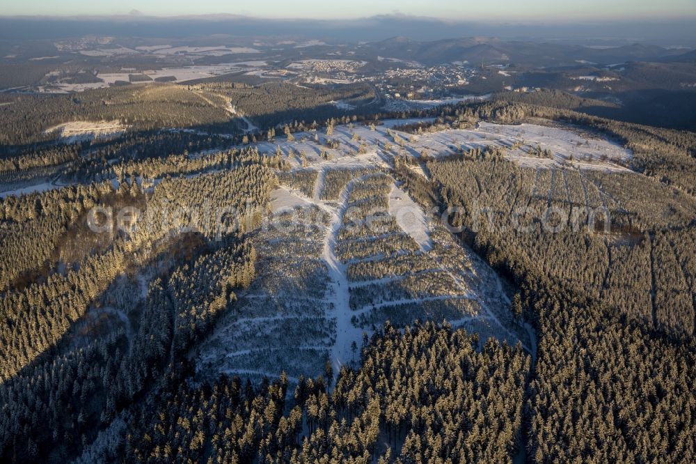 Aerial photograph Winterberg - Plateau and landscape on the snow-covered mountain Kahler Asten in Winterberg in the state of North Rhine-Westphalia. The mountain is the third highest in the Rothaar Mountain Range region. On top of the mountain sits the hotel-restaurant and the green tower - both visible in the background. It is also part of the winter sports resort of Skiliftkarussell Winterberg