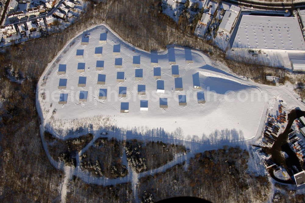 Aerial photograph Bottrop - Blick auf die verschneite Photovoltaikanlage auf der ehemaligen Deponie am Südring, Bottrop in Nordrhein-Westfalen. Die Anlage versorgt den Fahrzeugpark, des Entsorgungsunternehmen BEST, mit Energie. View of the snowy photovoltaic plant on the former landfill on Südring, Bottrop in North Rhine-Westphalia. The plant supplies the car park of the waste management company BEST, with energy.