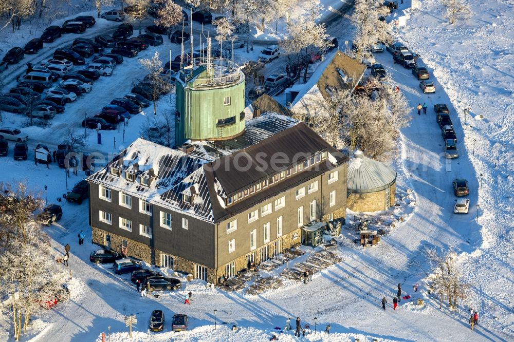 Aerial photograph Winterberg - Winterly hotel-restaurant and Asten Tower on the snow-covered mountain Kahler Asten in Winterberg in the state of North Rhine-Westphalia. The mountain is the third highest in the Rothaar Mountain Range region. On top of the mountain sits the hotel-restaurant and the green tower. It is also part of the winter sports resort of Skiliftkarussell Winterberg