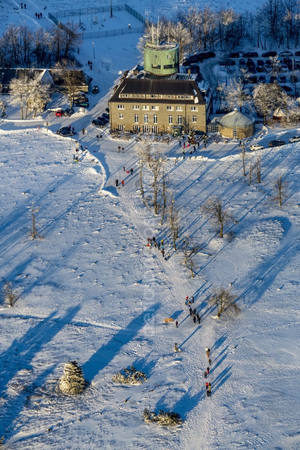 Winterberg from the bird's eye view: Winterly hotel-restaurant and Asten Tower on the snow-covered mountain Kahler Asten in Winterberg in the state of North Rhine-Westphalia. The mountain is the third highest in the Rothaar Mountain Range region. On top of the mountain sits the hotel-restaurant and the green tower. It is also part of the winter sports resort of Skiliftkarussell Winterberg