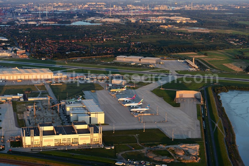 Hamburg from above - View of the in-plant airport of Airbus Deutschland GmbH at the river- side of the Elbe illuminated by the evening sun in Hamburg with four airplanes model Airbus A380-800 casting long shadows