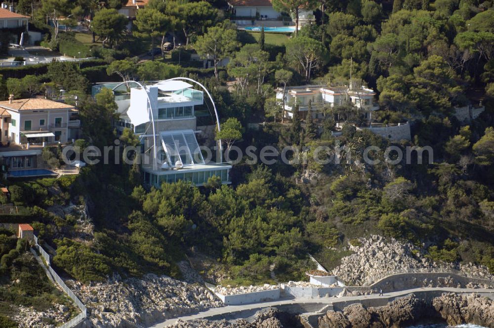 Aerial photograph Saint-Jean-Cap-Ferrat - Blick auf Villen auf der Halbinsel Saint-Jean-Cap-Ferrat. Das Cap Ferrat ist eine Halbinsel an der Cote d' Azur. Sie liegt zwischen Nizza und Monaco. Es trennt Beaulieu-sur-Mer und Villefranche-sur-Mer. Der Ort Saint-Jean-Cap-Ferrat erstreckt sich an seinem Ostufer. Die ganze Halbinsel kann auf einem Fußweg umrundet werden. An ihrer Spitze steht ein Leuchtturm als Hafenwegweiser.