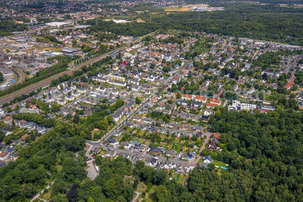 Castrop-Rauxel from the bird's eye view: Surrounded by forest and forest areas center of the streets and houses and residential areas on street Schulstrasse in the district Bladenhorst in Castrop-Rauxel at Ruhrgebiet in the state North Rhine-Westphalia, Germany