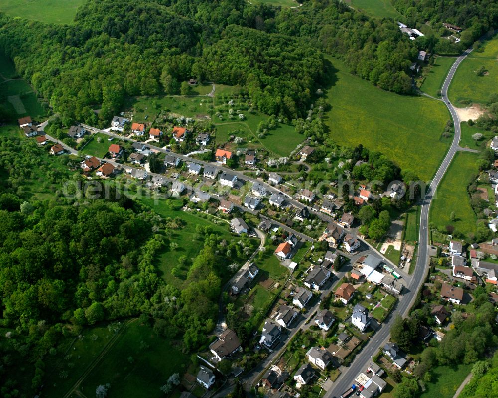 Oberscheld from the bird's eye view: Surrounded by forest and forest areas center of the streets and houses and residential areas in Oberscheld in the state Hesse, Germany