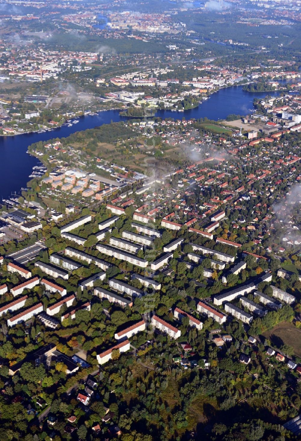 Berlin from above - Cityscape traversed by clouds overlooking the autumnal district of Koepenick along the river Dahme witha view of the Rohrwall-Island in Berlin. Residential areas and green space along Wendenschlossstrasse