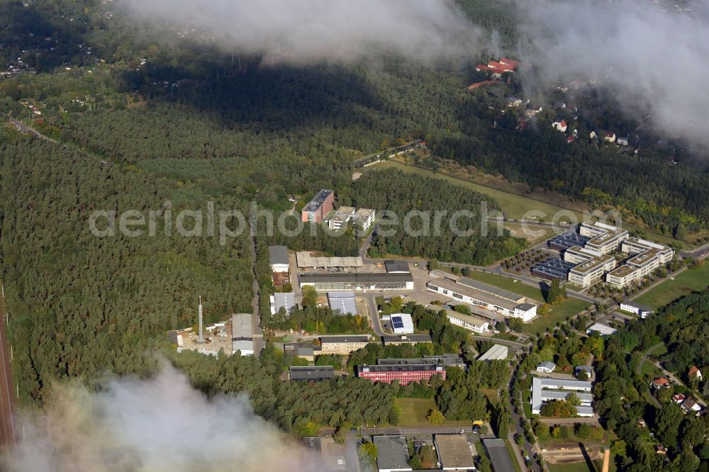 Aerial photograph Berlin - View of clouds surrounding the campus of commercial area Wuhlheide Innovation Park in Berlin - Koepenick. The industrial area at Verlaengerte Kopenicker Strasse is location of many predominantly technology-oriented companies from various business branches. Operator is the Innovationspark Wuhlheide Managementgesellschaft mbH