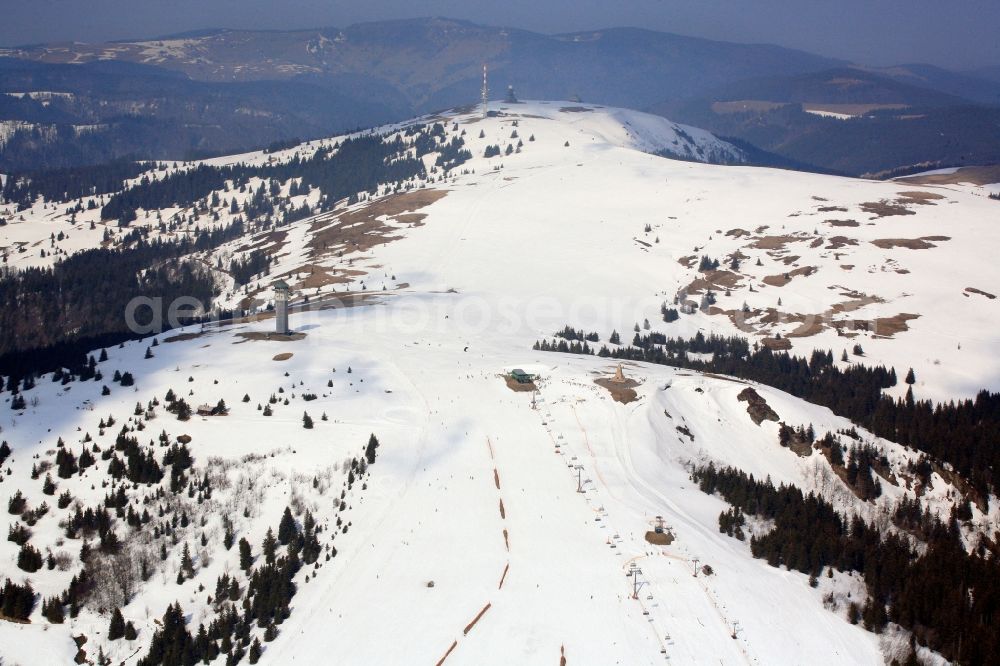 Aerial image Feldberg (Schwarzwald) - Forest and mountain scenery of the summit region of the Feldberg in Feldberg (Schwarzwald) in Baden-Wuerttemberg. Snow and patches of snow in the winter sports resort on the highest mountain in the Black Forest