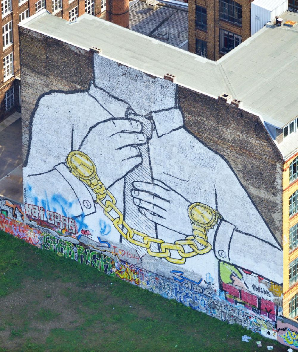 Aerial photograph Berlin - Wandgemälde an der Cuvrystraße Ecke Schlesische Straße in Berlin-Kreuzberg des italienischen Street-Art-Künstlers Blu. Es zeigt einen kopflosen Krawattenträger mit golden Uhren als Handschellen. Mural painting in Berlin-Kreuzberg of the italien street art artist Blu.