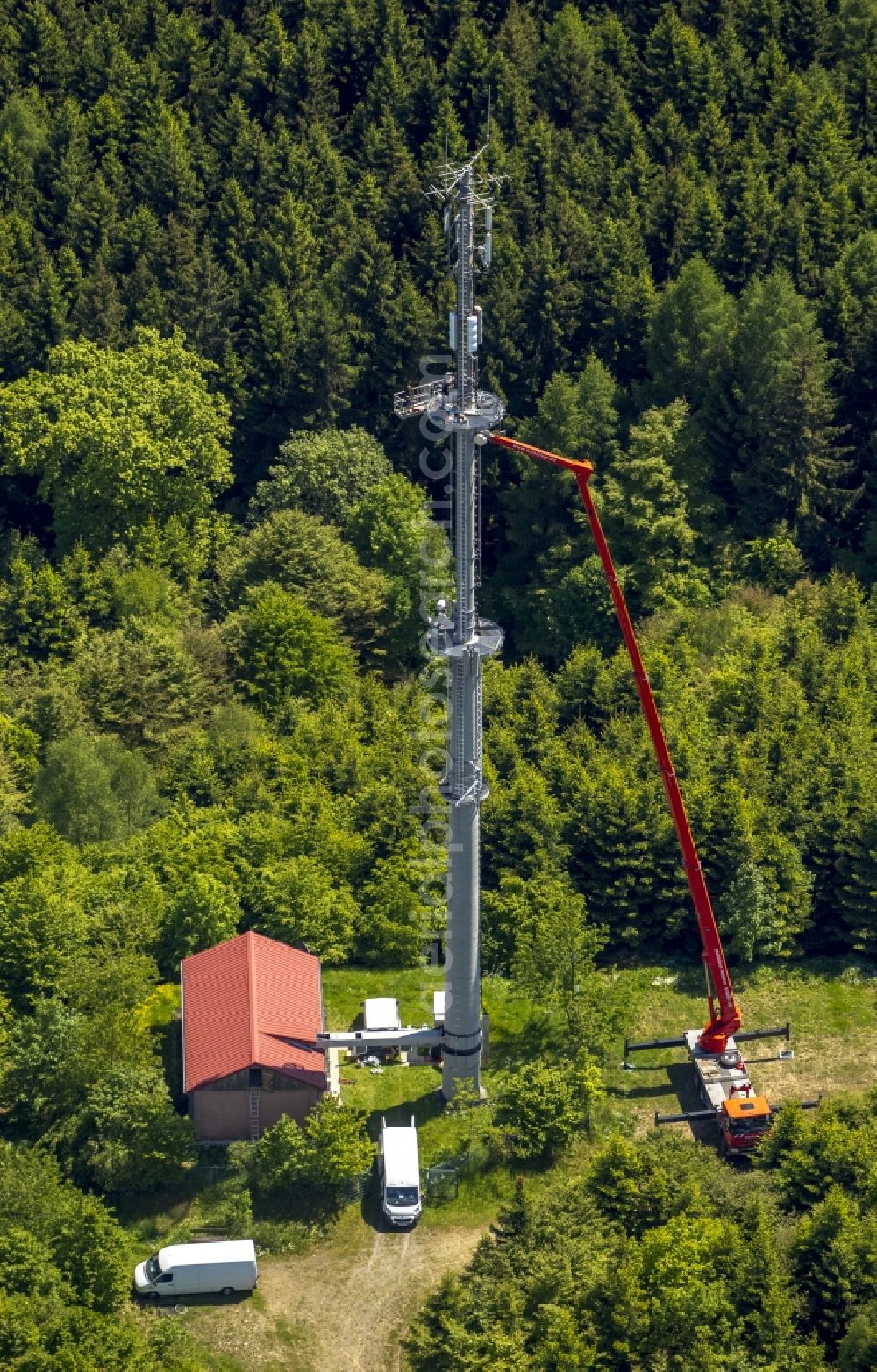 Bad Laasphe from the bird's eye view: Maintenance of mobile crane on the platform of a mobile radio transmission tower for telecommunications in Bad Laasphe in the state of North Rhine-Westphalia