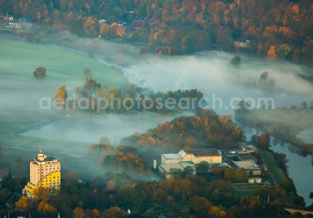 Aerial photograph Essen - Water works and residential building for the elderly House under the rainbow in the autumnal valley of the Ruhr in the Ueberruhr-Hinsel part of Essen in the state of North Rhine-Westphalia. The home has a distinct colourful facade. The water works stand next to it in the fog covered valley of the river