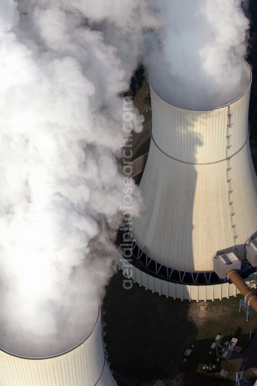 Aerial image Schwarze Pumpe - Im Rahmen der Errichtung des VEB Gaskombinat Schwarze Pumpe wurden auf dem Gelände des heutigen Industrieparks auch drei Kraftwerke mit der Bezeichnung Kraftwerk Schwarze Pumpe West, Mitte und Ost in Betrieb genommen. Der erste Kraftwerksblock lieferte ab 1959 Elektroenergie sowie Prozessdampf. Die Blockleistungen betrugen zwischen 25 und 100 MW. Das Kraftwerk Schwarze Pumpe wurde als Gemeinschaftskraftwerk von den damals noch eigenständigen Unternehmen VEAG und den Energiewerke Schwarze Pumpe AG (ESPAG) geplant und gebaut. Der entsprechende Vertrag dazu wurde am 13. Februar 1992 unterzeichnet und im März des selben Jahres wurde der Planungsauftrag für einen Kraftwerksbau an die SIEMENS AG, München erteilt.Neben der Erzeugung von Elektroenergie gehört die Bereitstellung von Prozessdampf für Unternehmen im nahe gelegenen Industriepark Schwarze Pumpe, sowie die Versorgung der Städte Spremberg, Hoyerswerda und des Ortsteil Schwarze Pumpe mit Fernwärme zu dessen wichtigsten Aufgaben. Das Kraftwerk Schwarze Pumpe gehört mit seinen etwa 360 Arbeitnehmern zu einen der größten Arbeitgebern der Region.