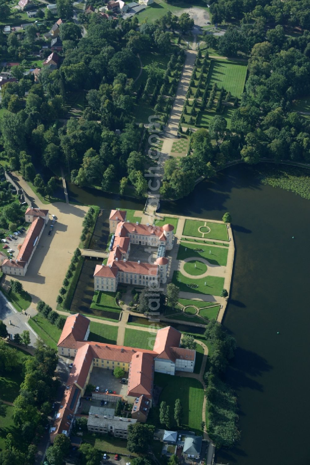 Aerial photograph Rheinsberg - Building and castle park systems of water castle Schloss Rheinsberg and the following building of the conservatoire Musikakademie Rheinsberg GmbH Kavalierhaus in Rheinsberg in the state Brandenburg