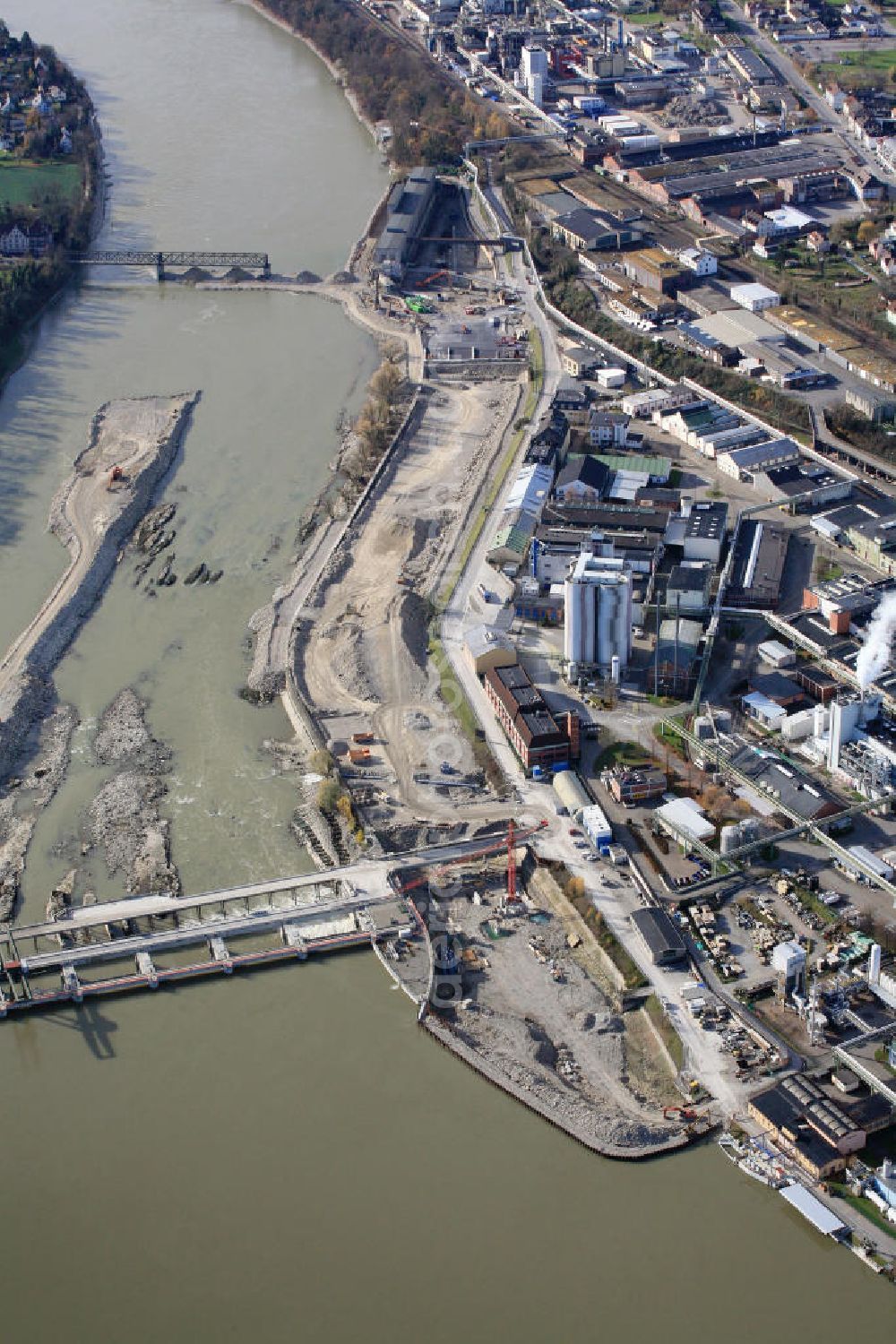 Aerial image Rheinfelden - Blick auf die Baustelle Wasserkraftwerk Rheinfelden zwischen den beiden gegenüberliegenden Städten Rheinfelden AG auf der Schweizer Seite und Rheinfelden (Baden) auf der deutschen Seite des Hochrheins. Größte Wasserkraftbaustelle Europas. Rechts im Bild der bereits verfüllte Zuflusskanal zum alten Kraftwerk. In diesem bereich wird ein naturnahes Fischaufstiegs- und Laichgewässer entstehen. Construction site of the hydropower plant in Rheinfelden.