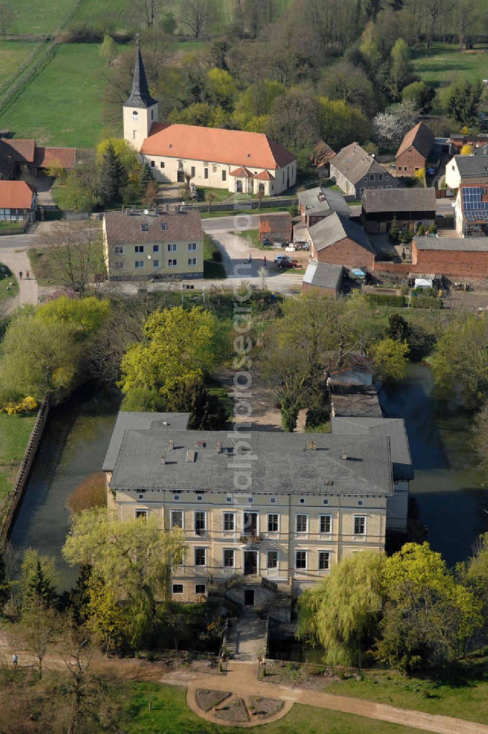 ANGERN from above - Blick auf das Schloss / Wasserschloss Angern. Im Jahr 1341 hatte Erzbischof Otto, Landgraf von Hessen, von Magdeburg in Angern das Schloss als Burg mit Wassergraben errichten lassen. Nach häufigen wechsel der Eigentümer wurde das Schloss 1384 im Auftrag des Erzbischof Albrecht IV saniert. In den Jahren bis 1424 wurde das Schloss oft verpfändet und wechselte dadurch sehr häufig den Besitzer, bis es schließlich in den Besitz der Familie von der Schulenburg fiel. Fast fünfhundert Jahre bis 1947. Von 1949 bis 1990 war in dem Schloss eine landwirtschaftliche Berufsschule untergebracht. 1997 erwarb die Familie von der Schulenburg das Schloss wieder.