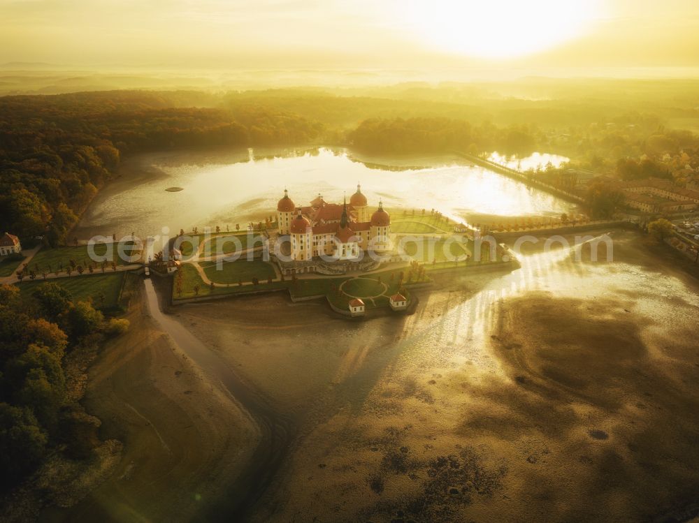 Moritzburg from the bird's eye view: Sunrise over the hunting and moated castle and castle park in the castle pond in Moritzburg in the federal state of Saxony, Germany