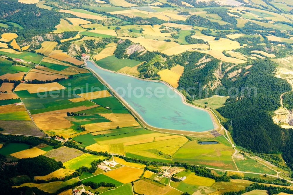 Aerial image Lazer - Water reservoir and lake for agricultural irrigation in summer from melting water in Lazer in Provence-Alpes-Cote d'Azur, France