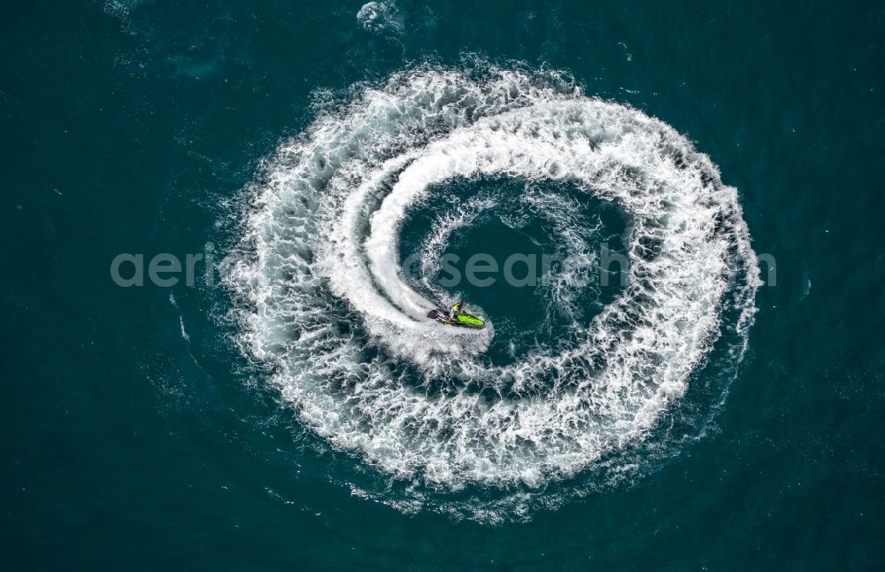 Agde from above - By waves and foam crests of watersports curves and circular drive with turbulence Mediterranean surface water off the coast in Agde in France
