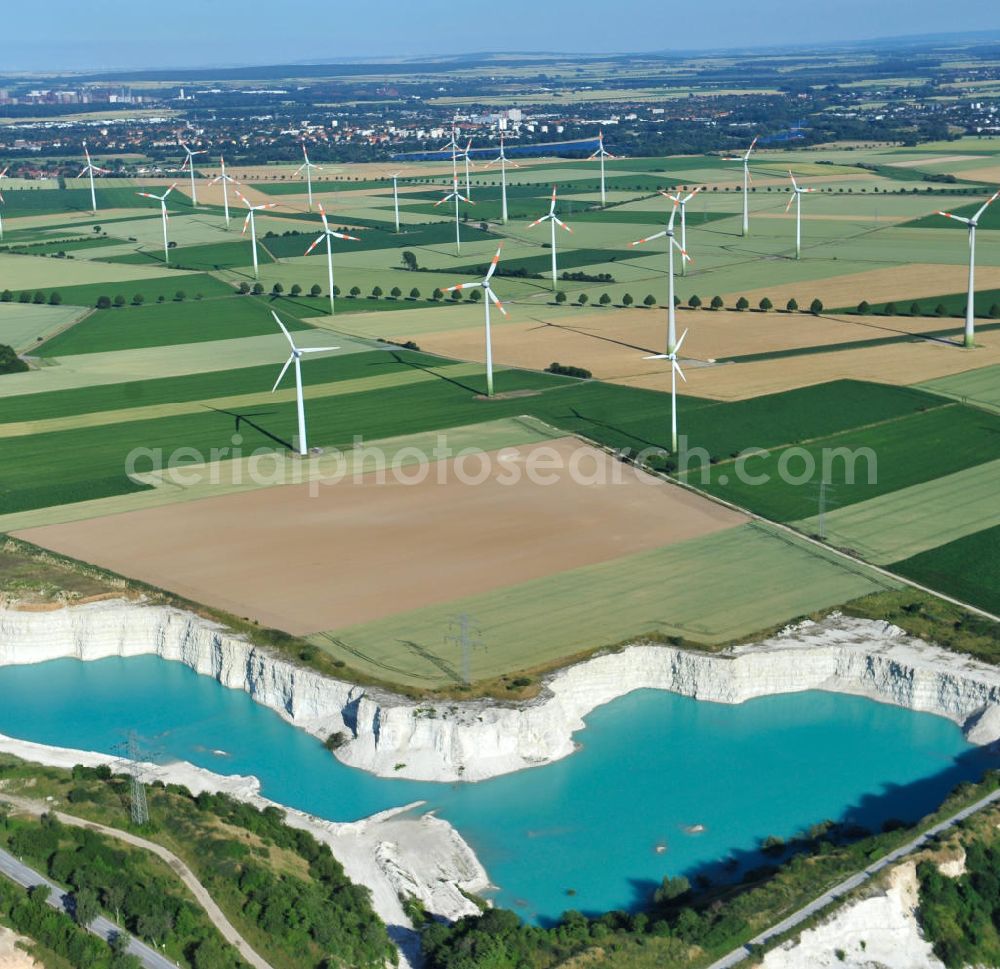 Aerial image Söhlde - Blick auf den blau schimmernden Wasserstand im Kalksandsteinwerk an der Barbecker Straße in Söhlde vor dem Hintergrund eines Windradfeldes. Lime production in Söhlde.