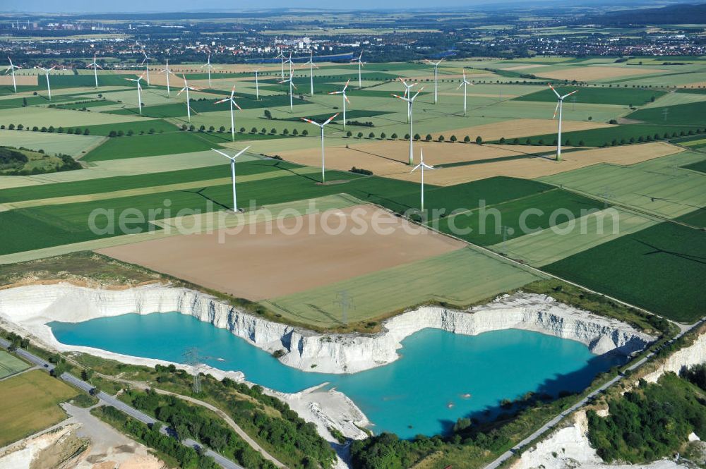 Aerial photograph Söhlde - Blick auf den blau schimmernden Wasserstand im Kalksandsteinwerk an der Barbecker Straße in Söhlde vor dem Hintergrund eines Windradfeldes. Lime production in Söhlde.