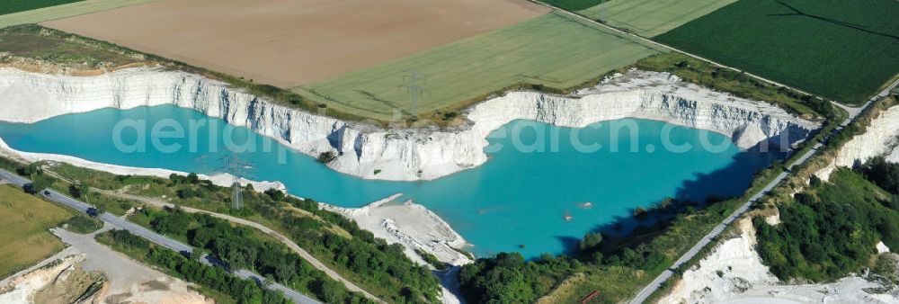 Söhlde from above - Blick auf den blau schimmernden Wasserstand im Kalksandsteinwerk an der Barbecker Straße in Söhlde vor dem Hintergrund eines Windradfeldes. Lime production in Söhlde.