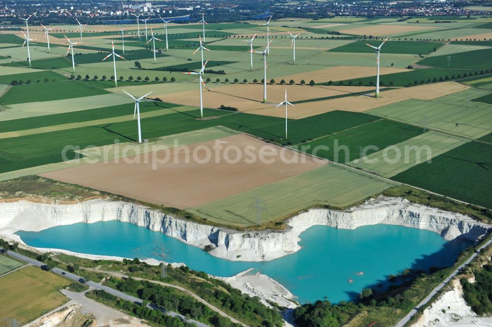 Söhlde from the bird's eye view: Blick auf den blau schimmernden Wasserstand im Kalksandsteinwerk an der Barbecker Straße in Söhlde vor dem Hintergrund eines Windradfeldes. Lime production in Söhlde.