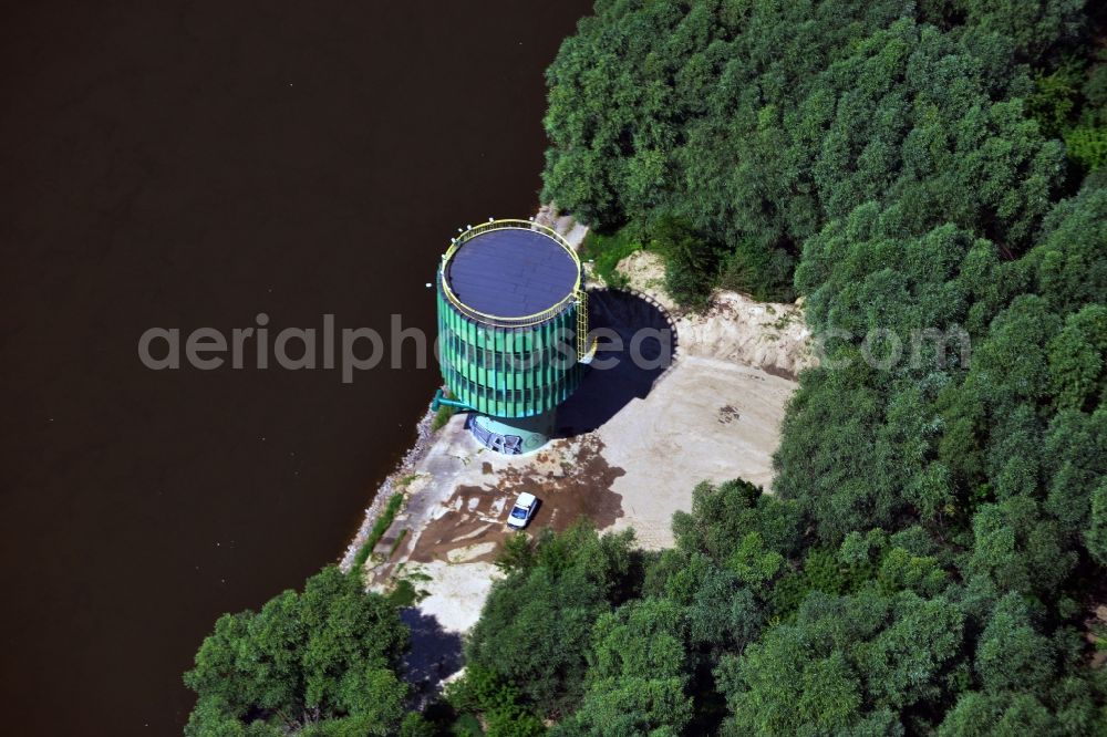 Warschau from the bird's eye view: Water tank on the Northern riverbank of the river Wisla in the East of Warsaw in Poland. The flamboyant turquoise tank is located right on the regulated bank in a forest