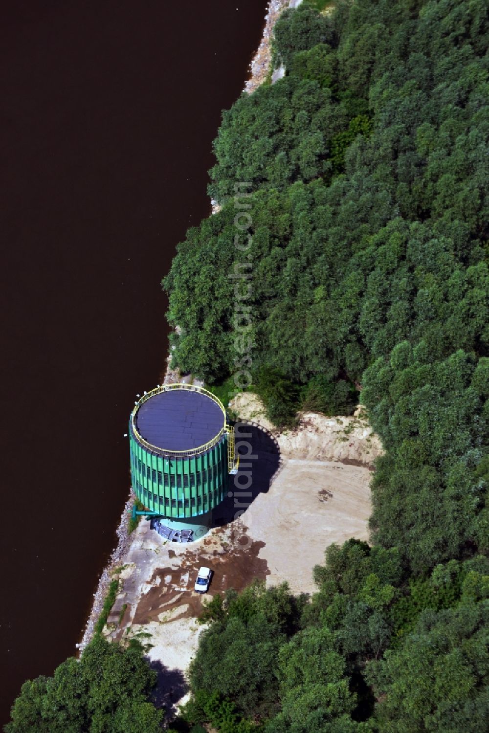 Aerial image Warschau - Water tank on the Northern riverbank of the river Wisla in the East of Warsaw in Poland. The flamboyant turquoise tank is located right on the regulated bank in a forest