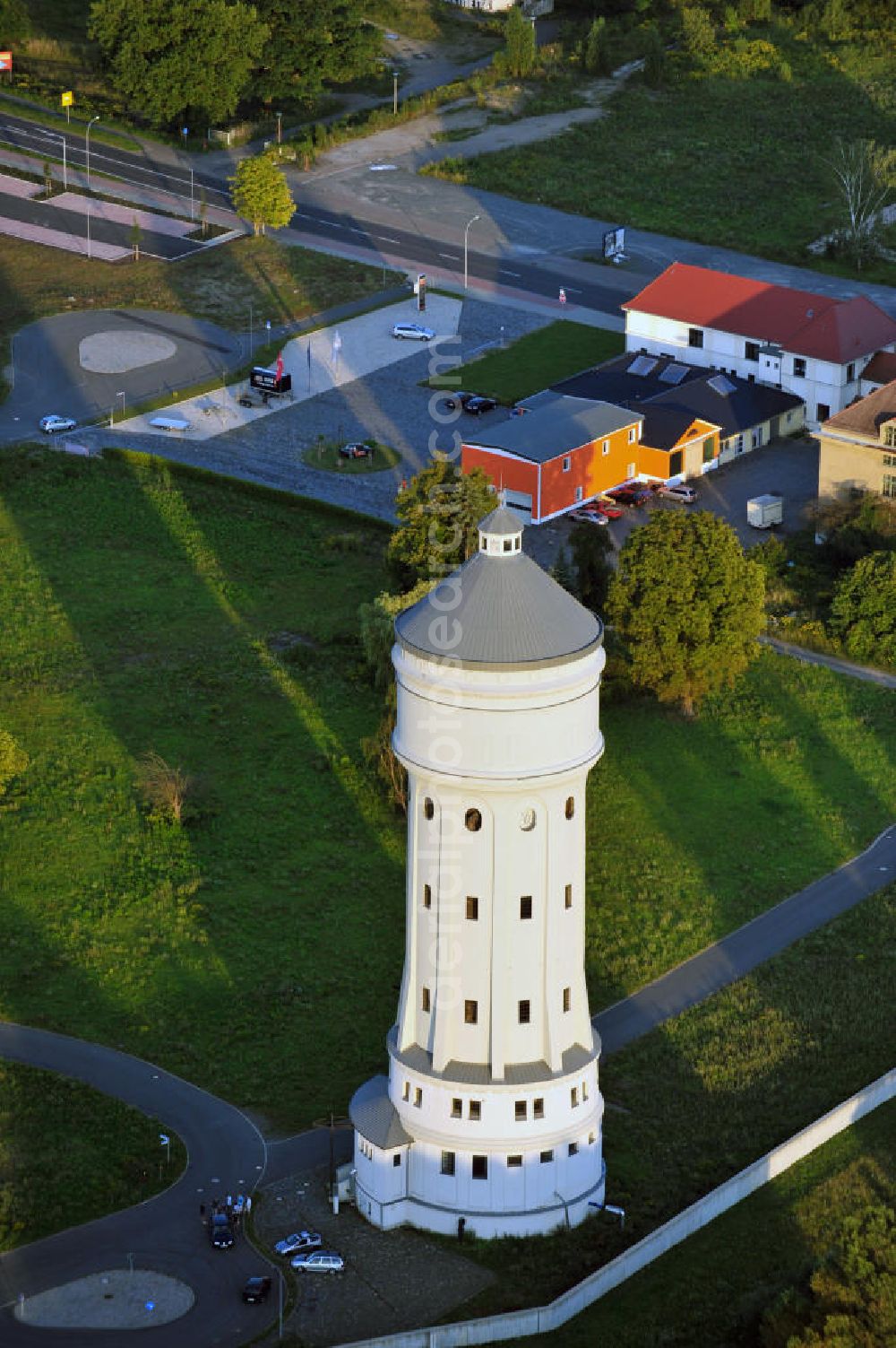 Aerial image Eilenburg - Der etwa 60 Meter hohe Wasserturm in Eilenburg-Ost in Sachsen wurde 1916 in der aufwendigen Bauart Otto Intzes vom Unternehmen Dyckerhoff und Widmann AG für die große Zelluloidfabrik gebaut. Nachdem er in der Zeit der DDR immer mehr verfallen war, wurde er im Jahr 2002 wieder instandgesetzt. Der Turm dient nun als Löschwasserspeicher für das benachbarte Industrie- und Gewerbegebiet Kunstoffcenter am ECW-Wasserturm und gilt als das wohl eindrucksvollste technische Denkmal der Stadt. About 60 metres high water tower in Eilenburg-East in Saxony was build 1916 in elaborate style of Otto Intzes by company Dyckerhoff und Widmann AG for a big celluloid factory. Gone to rack during the time of DDR, the tower was refurbished in 2002. It now serves as a fire water reservoir for industrial area Kunstoffcenter am ECW-Wasserturm nearby and is regarded as the most impressive technical monument of the town.