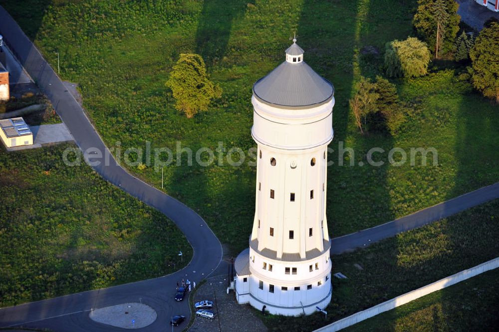 Eilenburg from the bird's eye view: Der etwa 60 Meter hohe Wasserturm in Eilenburg-Ost in Sachsen wurde 1916 in der aufwendigen Bauart Otto Intzes vom Unternehmen Dyckerhoff und Widmann AG für die große Zelluloidfabrik gebaut. Nachdem er in der Zeit der DDR immer mehr verfallen war, wurde er im Jahr 2002 wieder instandgesetzt. Der Turm dient nun als Löschwasserspeicher für das benachbarte Industrie- und Gewerbegebiet Kunstoffcenter am ECW-Wasserturm und gilt als das wohl eindrucksvollste technische Denkmal der Stadt. About 60 metres high water tower in Eilenburg-East in Saxony was build 1916 in elaborate style of Otto Intzes by company Dyckerhoff und Widmann AG for a big celluloid factory. Gone to rack during the time of DDR, the tower was refurbished in 2002. It now serves as a fire water reservoir for industrial area Kunstoffcenter am ECW-Wasserturm nearby and is regarded as the most impressive technical monument of the town.