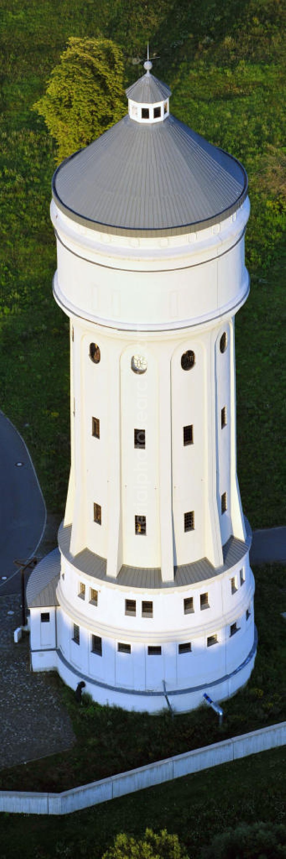 Aerial photograph Eilenburg - Der etwa 60 Meter hohe Wasserturm in Eilenburg-Ost in Sachsen wurde 1916 in der aufwendigen Bauart Otto Intzes vom Unternehmen Dyckerhoff und Widmann AG für die große Zelluloidfabrik gebaut. Nachdem er in der Zeit der DDR immer mehr verfallen war, wurde er im Jahr 2002 wieder instandgesetzt. Der Turm dient nun als Löschwasserspeicher für das benachbarte Industrie- und Gewerbegebiet Kunstoffcenter am ECW-Wasserturm und gilt als das wohl eindrucksvollste technische Denkmal der Stadt. About 60 metres high water tower in Eilenburg-East in Saxony was build 1916 in elaborate style of Otto Intzes by company Dyckerhoff und Widmann AG for a big celluloid factory. Gone to rack during the time of DDR, the tower was refurbished in 2002. It now serves as a fire water reservoir for industrial area Kunstoffcenter am ECW-Wasserturm nearby and is regarded as the most impressive technical monument of the town.