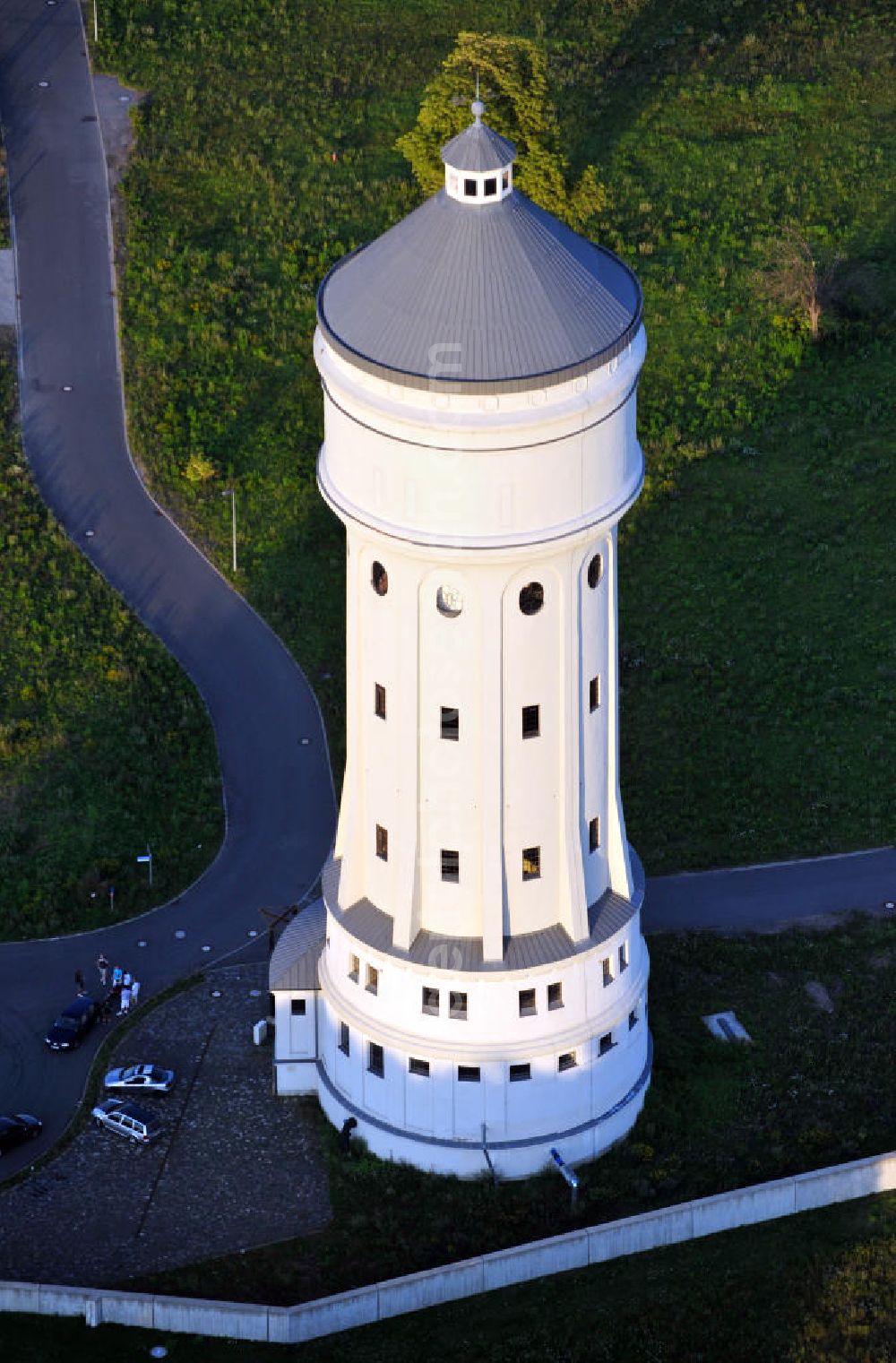 Eilenburg from the bird's eye view: Der etwa 60 Meter hohe Wasserturm in Eilenburg-Ost in Sachsen wurde 1916 in der aufwendigen Bauart Otto Intzes vom Unternehmen Dyckerhoff und Widmann AG für die große Zelluloidfabrik gebaut. Nachdem er in der Zeit der DDR immer mehr verfallen war, wurde er im Jahr 2002 wieder instandgesetzt. Der Turm dient nun als Löschwasserspeicher für das benachbarte Industrie- und Gewerbegebiet Kunstoffcenter am ECW-Wasserturm und gilt als das wohl eindrucksvollste technische Denkmal der Stadt. About 60 metres high water tower in Eilenburg-East in Saxony was build 1916 in elaborate style of Otto Intzes by company Dyckerhoff und Widmann AG for a big celluloid factory. Gone to rack during the time of DDR, the tower was refurbished in 2002. It now serves as a fire water reservoir for industrial area Kunstoffcenter am ECW-Wasserturm nearby and is regarded as the most impressive technical monument of the town.