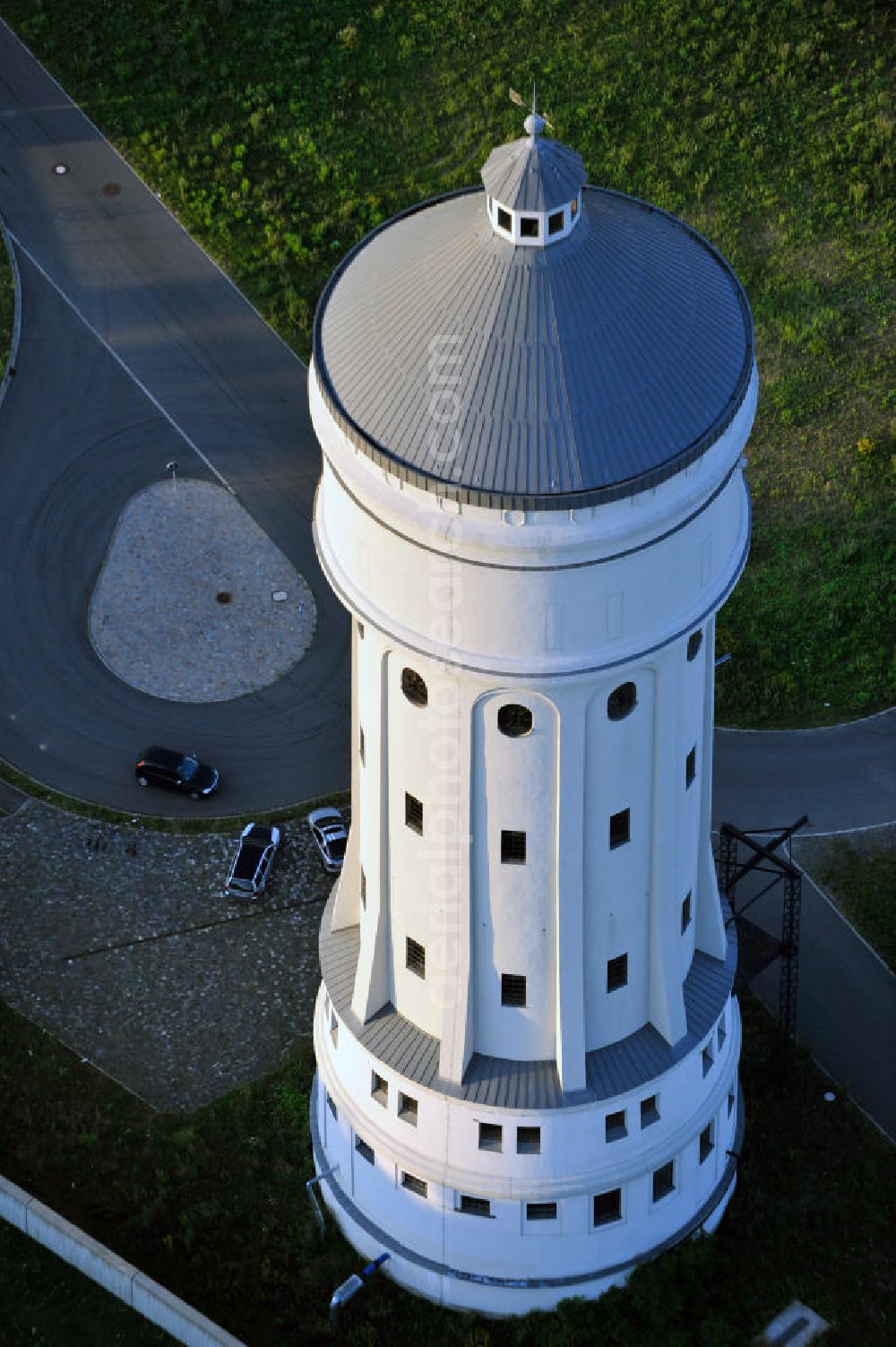 Aerial image Eilenburg - Der etwa 60 Meter hohe Wasserturm in Eilenburg-Ost in Sachsen wurde 1916 in der aufwendigen Bauart Otto Intzes vom Unternehmen Dyckerhoff und Widmann AG für die große Zelluloidfabrik gebaut. Nachdem er in der Zeit der DDR immer mehr verfallen war, wurde er im Jahr 2002 wieder instandgesetzt. Der Turm dient nun als Löschwasserspeicher für das benachbarte Industrie- und Gewerbegebiet Kunstoffcenter am ECW-Wasserturm und gilt als das wohl eindrucksvollste technische Denkmal der Stadt. About 60 metres high water tower in Eilenburg-East in Saxony was build 1916 in elaborate style of Otto Intzes by company Dyckerhoff und Widmann AG for a big celluloid factory. Gone to rack during the time of DDR, the tower was refurbished in 2002. It now serves as a fire water reservoir for industrial area Kunstoffcenter am ECW-Wasserturm nearby and is regarded as the most impressive technical monument of the town.