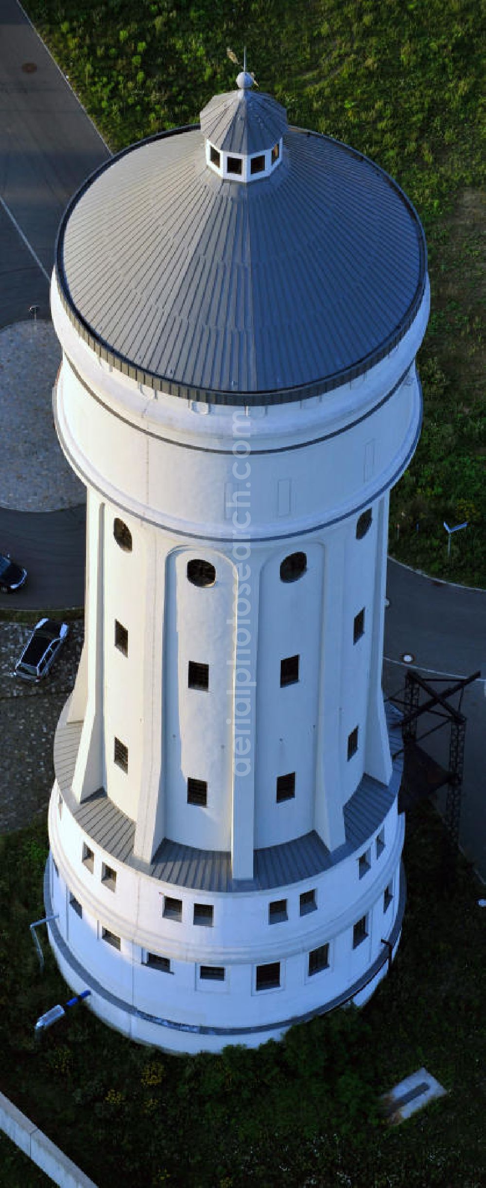 Aerial photograph Eilenburg - Der etwa 60 Meter hohe Wasserturm in Eilenburg-Ost in Sachsen wurde 1916 in der aufwendigen Bauart Otto Intzes vom Unternehmen Dyckerhoff und Widmann AG für die große Zelluloidfabrik gebaut. Nachdem er in der Zeit der DDR immer mehr verfallen war, wurde er im Jahr 2002 wieder instandgesetzt. Der Turm dient nun als Löschwasserspeicher für das benachbarte Industrie- und Gewerbegebiet Kunstoffcenter am ECW-Wasserturm und gilt als das wohl eindrucksvollste technische Denkmal der Stadt. About 60 metres high water tower in Eilenburg-East in Saxony was build 1916 in elaborate style of Otto Intzes by company Dyckerhoff und Widmann AG for a big celluloid factory. Gone to rack during the time of DDR, the tower was refurbished in 2002. It now serves as a fire water reservoir for industrial area Kunstoffcenter am ECW-Wasserturm nearby and is regarded as the most impressive technical monument of the town.